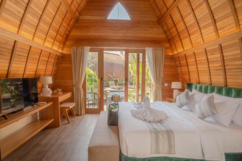 a bedroom with a bed and a tv in a room at Abian Klumpu Villa & Spa Sanur Bali in Sanur