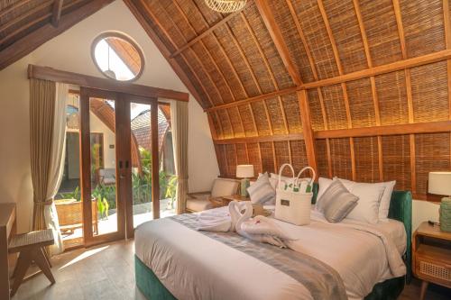 a bedroom with a large bed with a large window at Abian Klumpu Villa & Spa Sanur Bali in Sanur