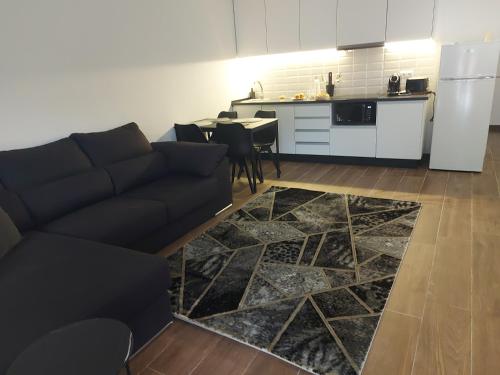 a living room with a couch and a kitchen at Recanto d'avo in Monção