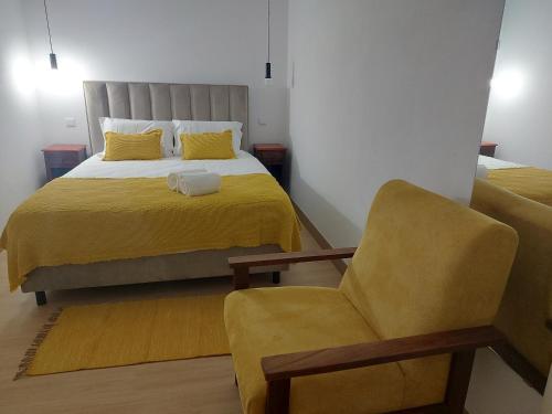 a bedroom with a bed and a chair at Recanto d'avo in Monção