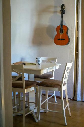 a white table and chairs with a guitar on the wall at Ballerina Bianca bed & breakfast in Grottazzolina