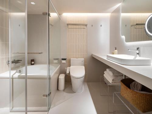 a white bathroom with a toilet and a sink at Lore Hotel in Taipei
