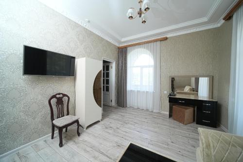 a room with a chair and a desk and a television at Jermuk Moscow Health Resort in Jermuk
