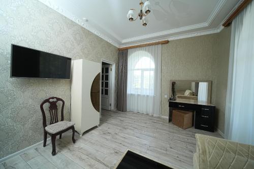 a living room with a chair and a television on the wall at Jermuk Moscow Health Resort in Jermuk