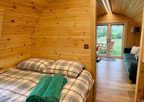 a bedroom with a bed in a wooden room at MTB Jumps View Pod in Trawsfynydd
