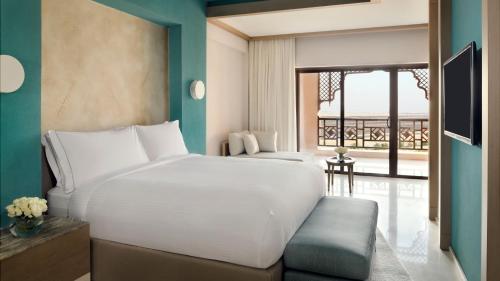 a bedroom with two beds and a balcony at InterContinental Durrat Al Riyadh Resort & Spa by IHG in Riyadh