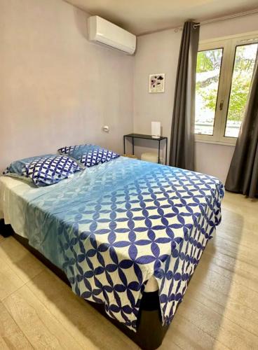 une chambre avec un lit avec une couette bleue et blanche dans l'établissement Villa spacieuse, au calme, en bord de rivière, à Lauroux