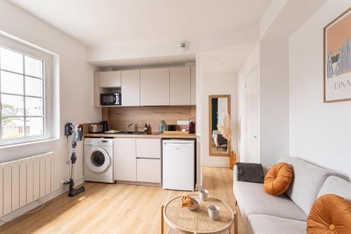 un salon avec un canapé et une cuisine dans l'établissement Le Clos Émeraude - Appt de 30 m² à Dinard, à Dinard