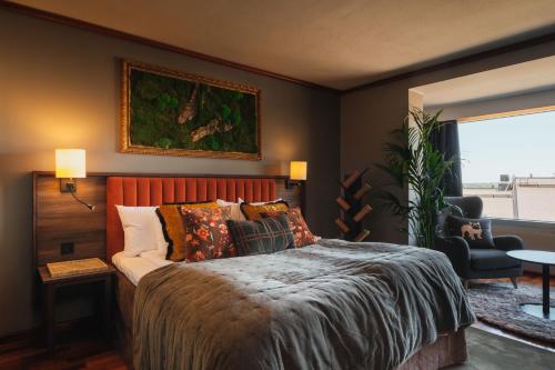 a bedroom with a bed and a chair and a window at Villa Foresta in Lidingö