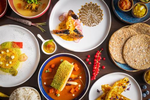 a table topped with plates of food and bowls of food at JA Palm Tree Court, Dubai in Dubai