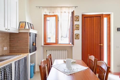 een keuken met een tafel en een raam en een tafel en stoelen bij Villa Rosa by Rentbeat in Montalbano