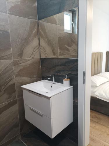 a bathroom with a white sink and a bed at Casa Jisa in Turda