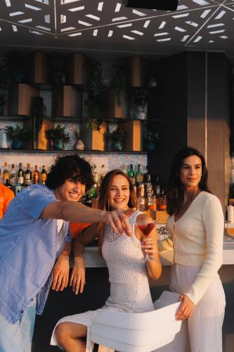 a group of three women posing for a picture at a bar at JA Palm Tree Court, Dubai in Dubai