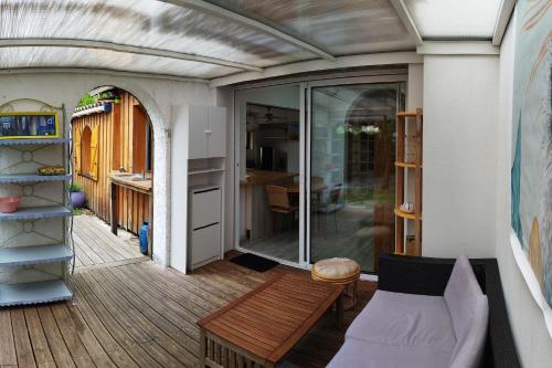 d'un balcon avec un banc en bois et une table. dans l'établissement A la petite maison, à Arès