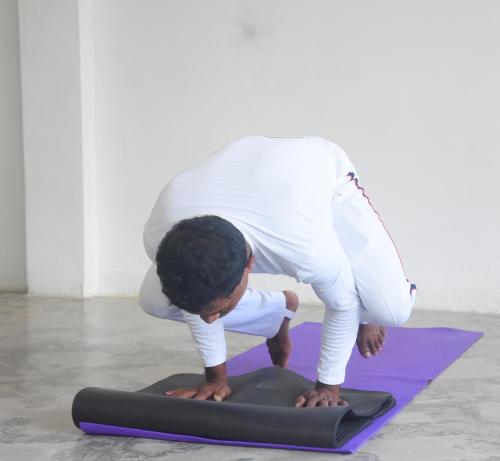 a man doing a yoga position on a yoga mat at Insa Guest House Kandy in Kandy