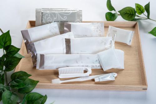 a wooden tray filled with white wrapping paper and a brush at Hotel Arashiyama in Kyoto