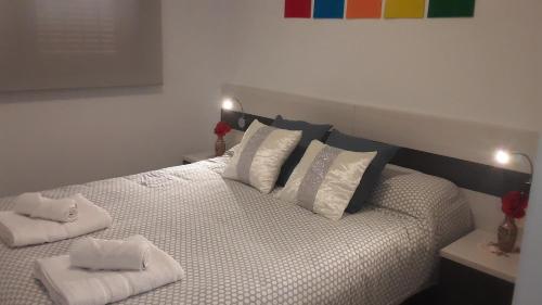 una camera da letto con un letto con due asciugamani sopra di Casa ARCO IRIS avec Jardin et Terrasse - piscine et jacuzzi partagés - by Cathy Ducoin a San Juan de los Terreros