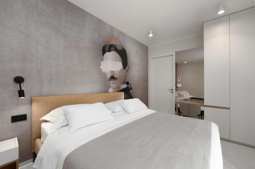 a bedroom with a white bed with a painting on the wall at The Q Whisper - new deluxe hideaway with sauna, jacuzzi and a garage in Rovinj