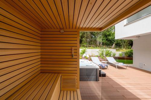 a wooden wall in a patio with a table and chairs at The Q Whisper - new deluxe hideaway with sauna, jacuzzi and a garage in Rovinj