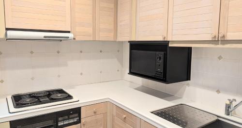 a kitchen with a stove and a microwave at Villa The Club 御殿場ウエスト in Gotemba