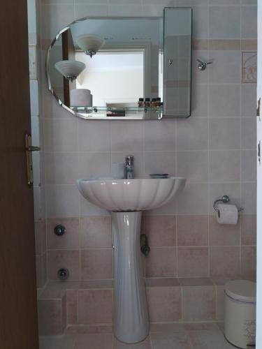 a bathroom with a white sink and a mirror at Vatoulia House in Neon Oitilon
