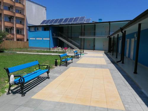 a row of blue benches in front of a building at хотел Ропотамо in Primorsko