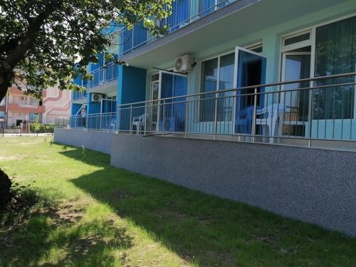 a blue building with balconies on the side of it at хотел Ропотамо in Primorsko