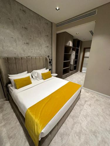 a bedroom with a large bed with yellow pillows at Voyage Residence فوياج ريسدينس للشقق المخدومة in Riyadh