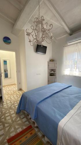 a bedroom with a blue bed and a chandelier at - La Casa di Rosi- Versilia & Free Parking- in Camaiore