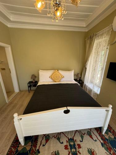 a bedroom with a large bed with a black blanket at Cunda Bebekli Pansiyon in Ayvalık