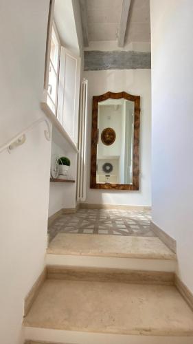 a staircase with a mirror in a white room at - La Casa di Rosi- Versilia & Free Parking- in Camaiore