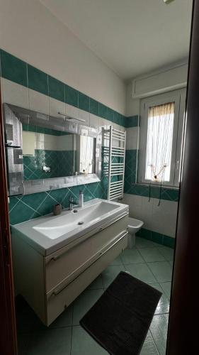 a bathroom with a sink and a mirror and a toilet at Hope Apartment in Pisa