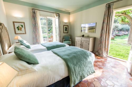 a bedroom with two beds and a large window at Château de Berne in Lorgues