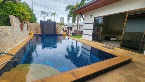a swimming pool with blue tiles in a house at Villa Grace in Ban Pak Khlong Phe