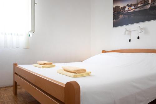 a bedroom with a white bed with towels on it at Kornati Paradise Residence Slanica in Murter