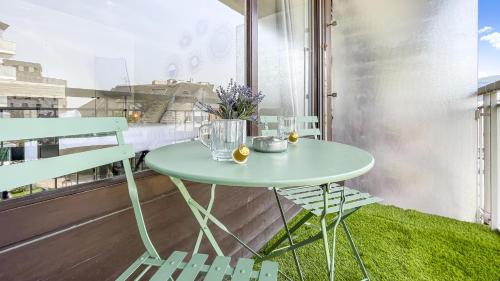 d'une table et de chaises vertes sur un balcon dans l'établissement Homey Garden - Parking Gratuit, Balcon, Proche Tram, Netflix, à Ambilly