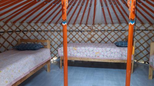 a bedroom with two beds in a yurt at Aisana ger camp in Ölgiy