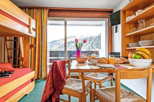 une salle à manger avec une table et des chaises et une fenêtre dans l'établissement Résidence Pierre & Vacances Les Bleuets, à Méribel