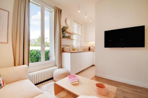 sala de estar con ventana grande y TV en Lovely Studio, en Boulogne-Billancourt