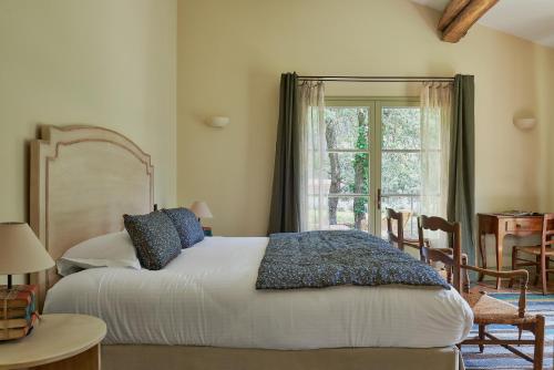 a bedroom with a large bed and a window at Château de Berne in Lorgues