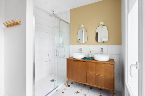 une salle de bain avec deux lavabos et une douche dans l'établissement Nouveau - Harmonia, à Nantes