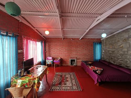 a living room with a couch and a brick wall at COZY HUTS in Kodaikānāl