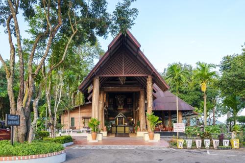 un tempio in una foresta con palme di OMD Wellness Resort at Bungasari a Ban Sap Bon
