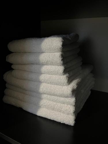 a stack of white towels sitting on a table at Cozy Newly Renovated Apartment in Batumi Old Town in Batumi