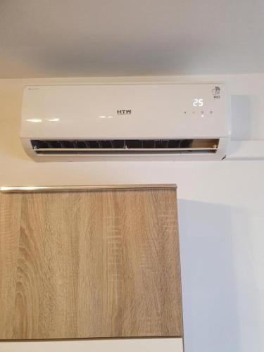 a white stove top oven with a wooden door at 3F, Aire Acondic, 80m2, 2 dormitorios, 4 huéspedes, WIFI GRATIS in La Línea de la Concepción