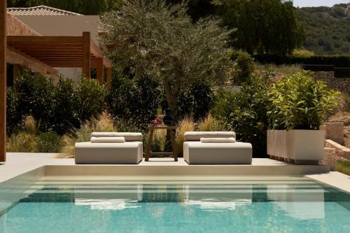 two lounge chairs next to a swimming pool at the Wildt - Exclusive Coastal Living in Argostoli