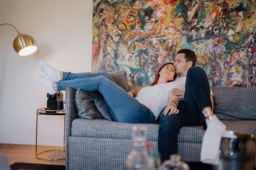 a man and a woman laying on a couch at De Merin Boutique Hotel Straden in Straden