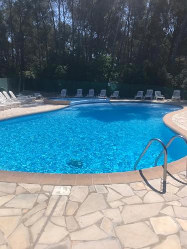 une grande piscine avec de l'eau bleue et des chaises dans l'établissement 15mn à pied commerces et plage, à Sanary-sur-Mer
