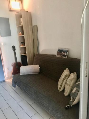 un salon avec un canapé et une guitare dans l'établissement 15mn à pied commerces et plage, à Sanary-sur-Mer
