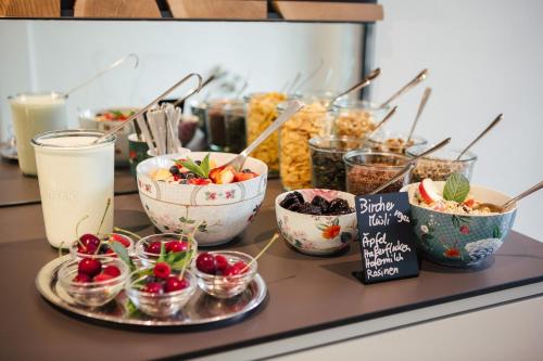 a buffet with bowls of food on a table at Hotel Garni Sirmian in Merano